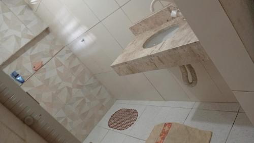 a bathroom with a stone sink and a shower at Seu Refúgio a 100m da Praia do Sobral - Maceió in Maceió