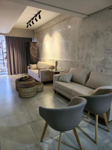 a living room with a couch and chairs at Murano Suits Hotel in João Pessoa