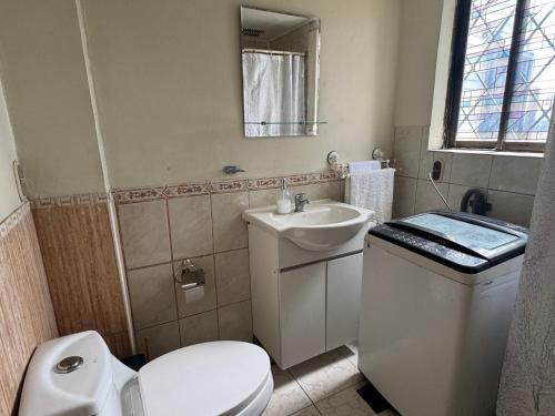 a bathroom with a white toilet and a sink at Family Summer House in Valparaíso