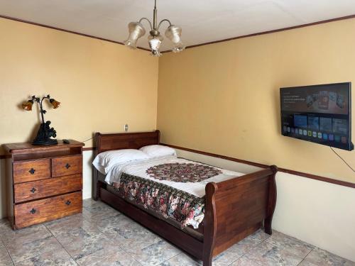 a bedroom with a bed and a dresser and a tv at Family Summer House in Valparaíso