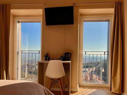 1 Schlafzimmer mit einem Bett und 2 Fenstern mit Aussicht in der Unterkunft BIXIO40 BED&BREAKFAST and APARTMENTS in Montefiascone