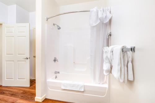 une salle de bain avec baignoire et douche avec serviettes dans l'établissement Berkshire Mountain Lodge, à Pittsfield