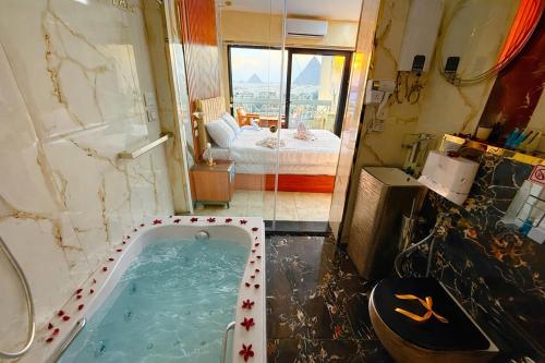 een badkamer met een jacuzzi en een slaapkamer bij Zoom Pyramids View inn in Caïro