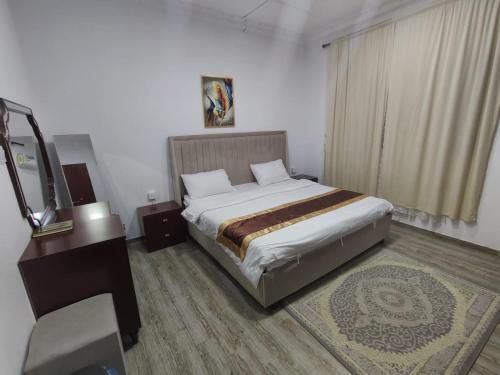 a bedroom with a bed and a dresser and a mirror at العروسة للشقق المخدومة in Tabuk