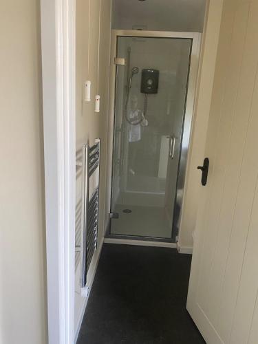 a bathroom with a shower with a glass door at The Stable in Stourton in Stourbridge