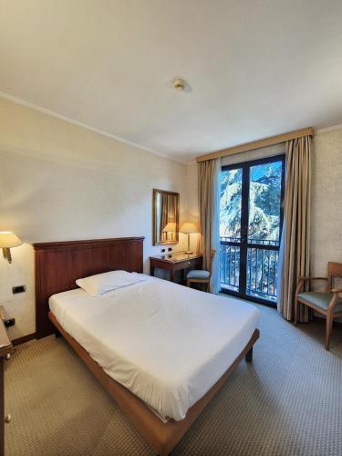 a bedroom with a large bed and a large window at Hotel Excelsior Magenta in Magenta