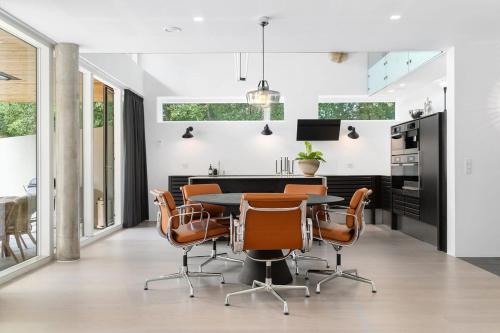 una cucina e una sala da pranzo con tavolo e sedie di Exclusive Duplex Mansion with Jacuzzi & Pool a Charlottenlund