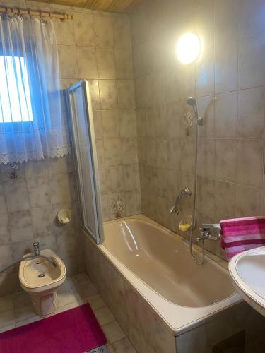 a bathroom with a tub and a toilet and a sink at Landhaus Weitblick in Paldau