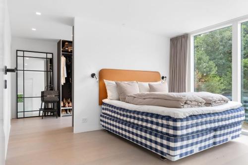 una camera da letto con un letto e una grande finestra di Exclusive Duplex Mansion with Jacuzzi & Pool a Charlottenlund