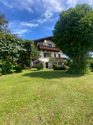 een huis met een boom voor een tuin bij Landhaus Weitblick in Paldau