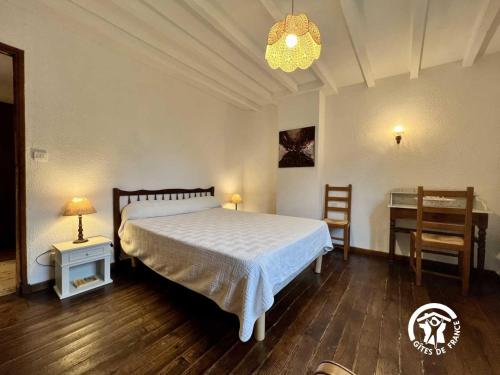 a bedroom with a bed and a table and a desk at Le gite fleuri in Limousis