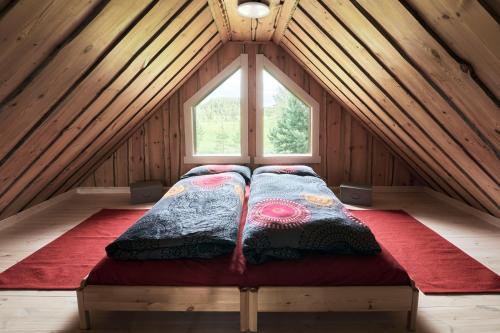 a bed in the middle of a room with a window at Capture Nordic Wilderness Camp in Ilomantsi