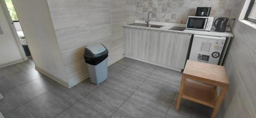 een kleine keuken met een wastafel en een vuilnisbak bij Hotel Palmas de La Serena in La Serena