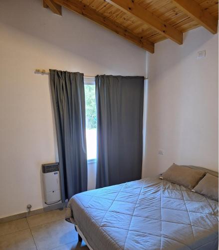 a bedroom with a bed and a window at Casa Rincon in Villa General Belgrano