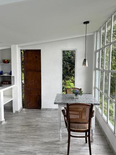 a dining room with a table and chairs and a door at Entre Nubes y Eucaliptos in Villamaría