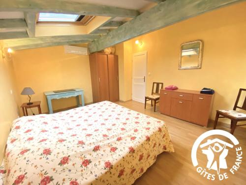 a bedroom with a bed and a table and chairs at La cave de jean in Gardie