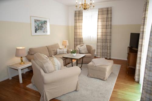 un soggiorno con un divano e una TV di Gästehaus Pfeiffer a Bad Mergentheim