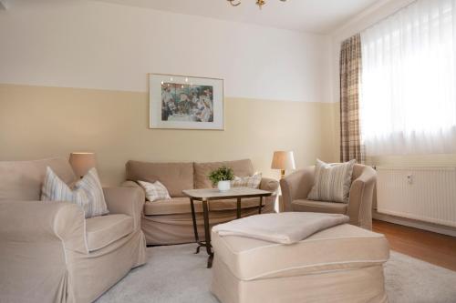 un soggiorno con un divano, sedie e un tavolo di Gästehaus Pfeiffer a Bad Mergentheim