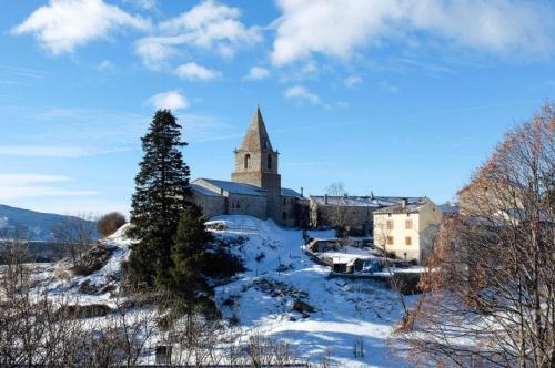 eine Kirche auf einem Hügel im Schnee in der Unterkunft Les lupins in Bolquere