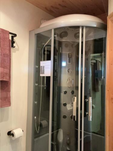 eine Dusche mit Glastür im Badezimmer in der Unterkunft Het Houten Huis in Hierden