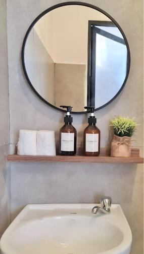 a bathroom with a mirror and a sink at EB Home Apartment in Mactan Island