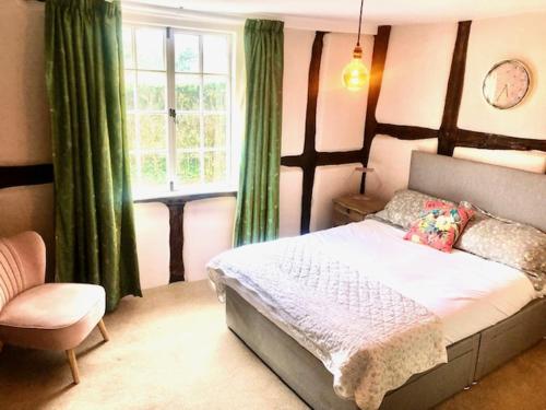 una camera da letto con un letto, una sedia e una finestra di Silvermead stables a Plymouth