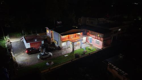 een huis waar 's nachts een auto voor geparkeerd staat bij Aarroh villa in Coonoor