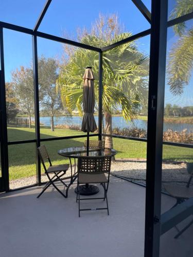 een patio met een tafel, 2 stoelen en een raam bij Loft à louer in Apollo Beach