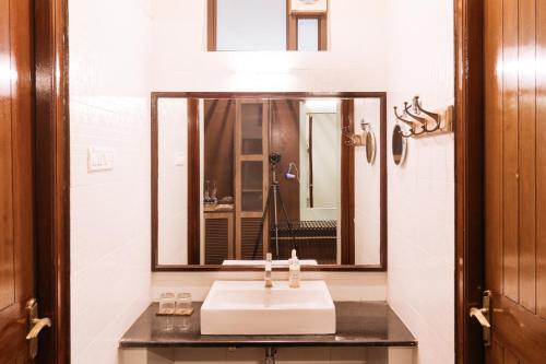 a bathroom with a sink and a large mirror at Discovery Village Kabini in Antarasante