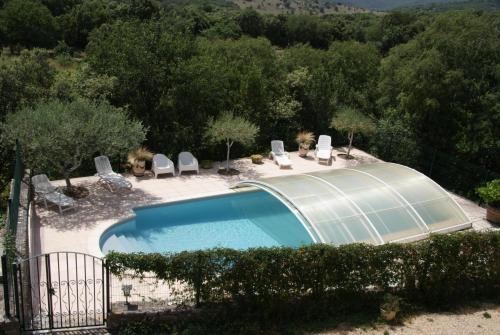 una piscina in un giardino con sedie intorno di Bergerie de la bueges a Saint-André-de-Buèges