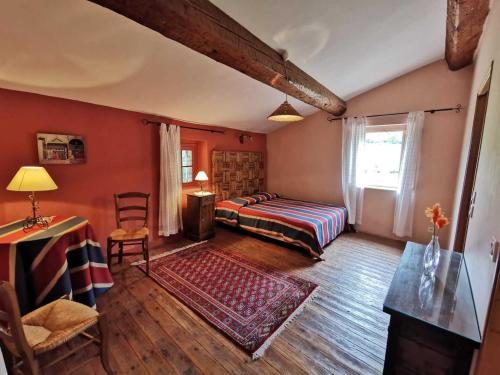 une chambre avec un lit, une table et une chaise dans l'établissement La maison du berger, à Cassagnes