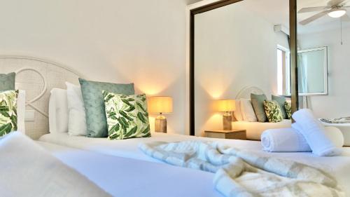 two white beds in a room with a mirror at MaraHomes in Funchal