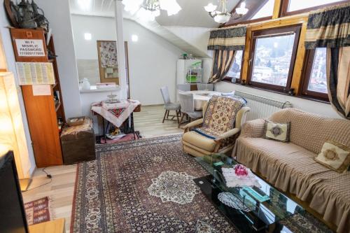 een woonkamer met een bank en een tafel bij Guest House Fena in Sarajevo