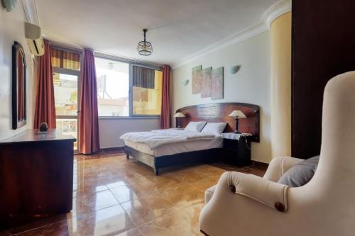 une chambre avec un lit et une chaise dedans dans l'établissement Arena Hostel, à Hurghada