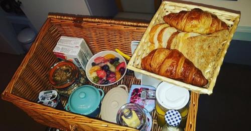 un cesto con pane e croissant su un tavolo di Silvermead stables a Plymouth