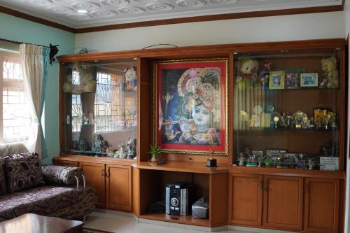 een woonkamer met een grote houten kast vol spullen bij Aarroh villa in Coonoor