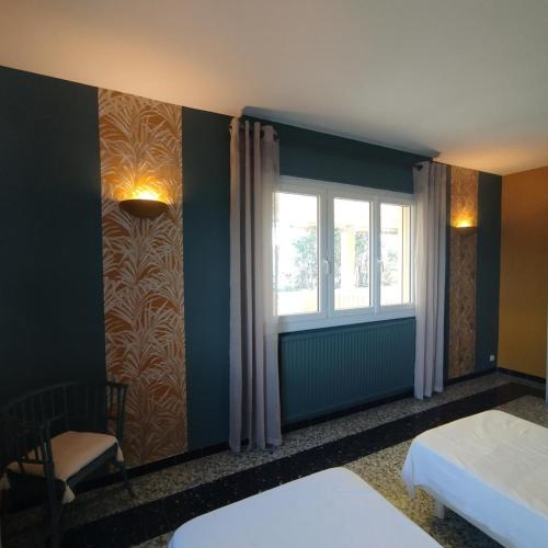 a room with two beds and a window at Louisiane in Sauvian