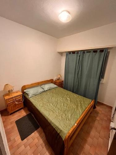 a bedroom with a bed with a green comforter at Depto San Bernardo céntrico2 in San Bernardo