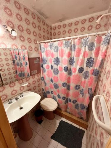 a bathroom with a sink and a toilet and a shower curtain at Depto San Bernardo céntrico2 in San Bernardo
