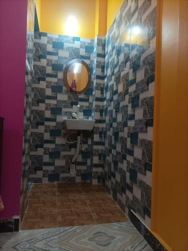 a bathroom with a sink and a mirror at Amullya Kanan Villa in Haldia