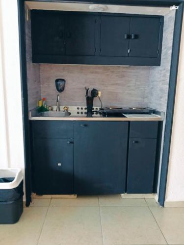 a kitchen with navy blue cabinets and a sink at SUITE TORRES GEMELAS 2902 vista al mar in Acapulco