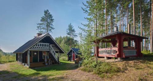 a small house and a small cabin in the woods at Capture Nordic Wilderness Camp - Baumzelt in Ilomantsi