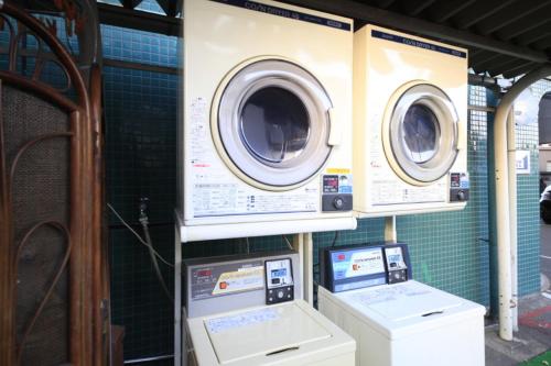 two washing machines and a washer and dryer on a wall at Chofu Urban Hotel in Chofu