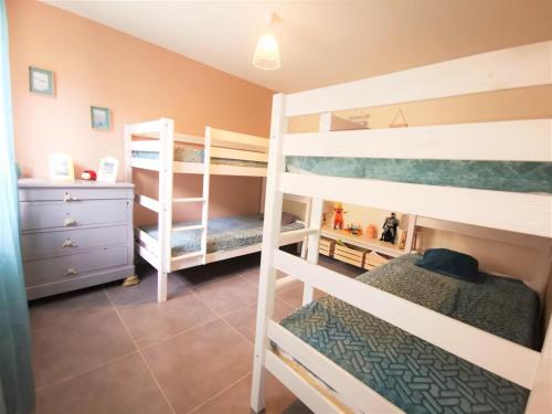 een slaapkamer met twee stapelbedden en een commode bij Me kasa in Agde