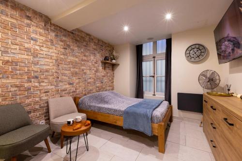 a bedroom with a bed and a brick wall at Au Spa de LLEA in Avignon