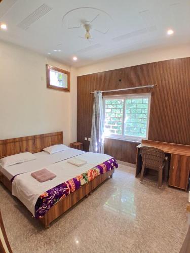 a bedroom with a bed and a desk and a window at WoodsPicker in Rishīkesh