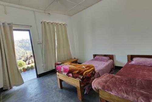a bedroom with two beds and a window and a chair at Vila's Homestay in Kohīma