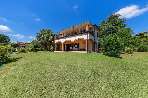 a house on a large grassy field with trees at Daller Bianca by Whale Homes in Soiano del Lago