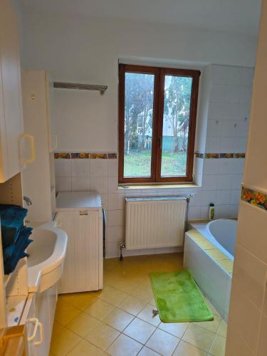 a bathroom with two sinks and a tub and a window at Juls garden apartment in Tulln