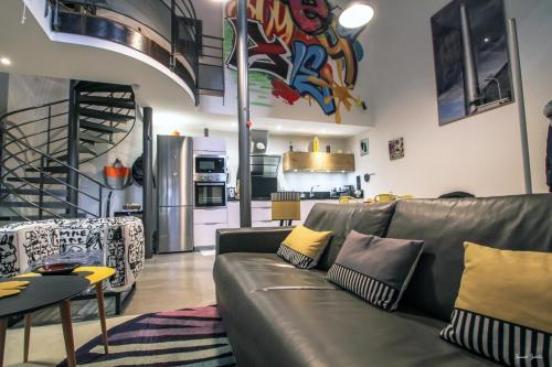 Loft 17 في Lisle-sur-Tarn: غرفة معيشة مع أريكة ومطبخ